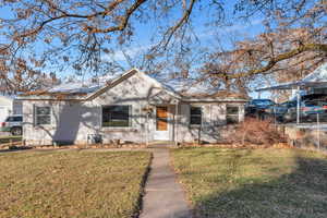 Bungalow-style home with a front lawn