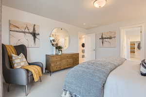 Bedroom featuring ensuite bathroom and light carpet