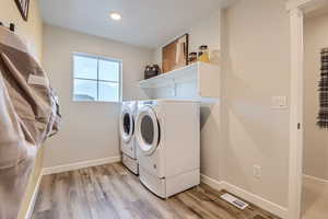 Washroom featuring washing machine and dryer and light style floors