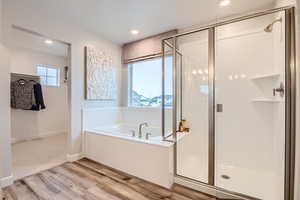 Primary bathroom featuring plus walk in shower, -LVP flooring, and a wealth of natural light