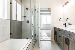 Bathroom featuring tile patterned floors, vanity, and separate shower and tub