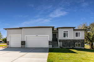 View of front of house featuring a front yard and a garage