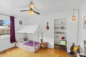 Bedroom featuring ceiling fan, wood-type flooring, and ornamental molding