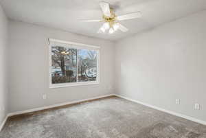 Carpeted spare room with ceiling fan