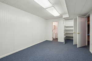 Unfurnished bedroom featuring dark carpet and ensuite bath