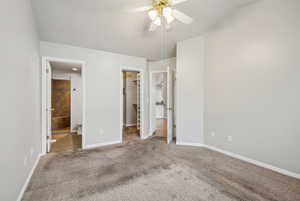 Unfurnished bedroom with ensuite bathroom, ceiling fan, a spacious closet, carpet floors, and a closet