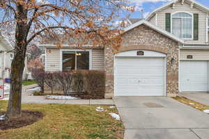 View of front facade featuring a garage and a front lawn