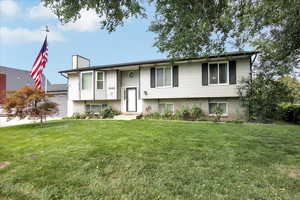 Split foyer home with a front lawn and a garage