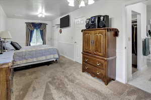 Bedroom with light colored carpet, ornamental molding, and a closet