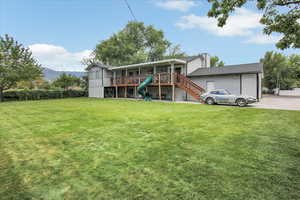 Back of property with a lawn and a wooden deck