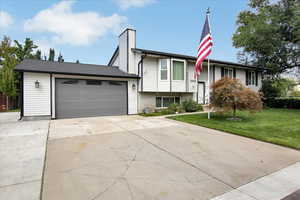 View of front of home with a garage and a front yard