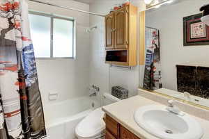 Full bathroom featuring vanity, toilet, and shower / bath combo with shower curtain