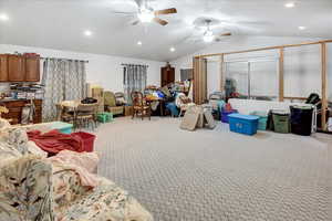 Interior space featuring carpet, ceiling fan, and lofted ceiling