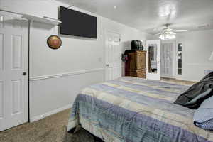 Bedroom featuring carpet flooring, a textured ceiling, ceiling fan, and crown molding