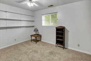 Interior space featuring ceiling fan and a textured ceiling