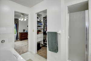 Bathroom featuring plus walk in shower and ceiling fan