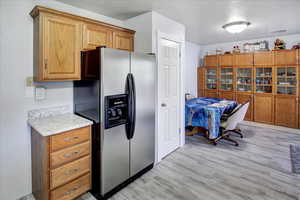 Kitchen with light hardwood / wood-style floors and stainless steel refrigerator with ice dispenser