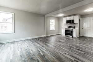 Unfurnished living room with dark hardwood / wood-style flooring