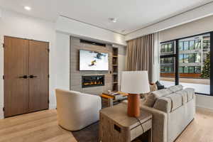 Living room with light hardwood / wood-style flooring and a tile fireplace