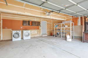 Garage featuring washer and clothes dryer and a garage door opener