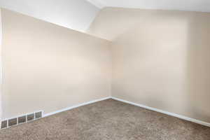 Interior space with carpet floors and vaulted ceiling