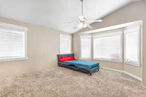 Bedroom featuring vaulted ceiling, ceiling fan, and carpet