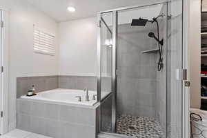 primary suite with  shower with separate bathtub and tile patterned floors