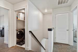 Stairs featuring washer / clothes dryer and carpet