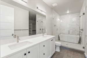 Full bathroom with toilet, tile patterned flooring, shower with separate bathtub, and vanity