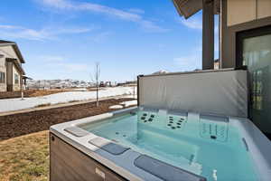 View of patio with a mountain view and a hot tub