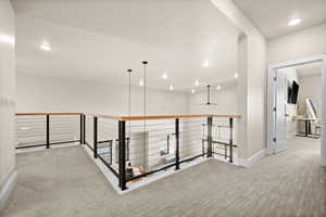 Hall with recessed lighting, carpet, baseboards, and an upstairs landing