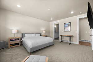 Carpeted bedroom with visible vents, recessed lighting, and baseboards