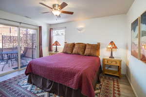 Bedroom with access to exterior, ceiling fan, and wood-type flooring