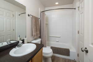 Full bathroom featuring shower / bathtub combination with curtain, vanity, and toilet