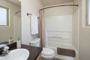 Full bathroom with vanity, toilet, and shower / bath combo with shower curtain