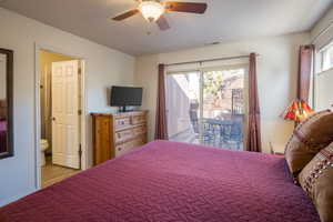 Bedroom featuring ceiling fan, access to exterior, and ensuite bath