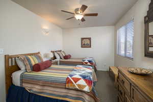 Bedroom featuring dark colored carpet and ceiling fan