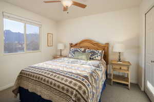 Carpeted bedroom with ceiling fan and a mountain view