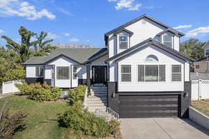 View of front facade featuring a front yard and a garage