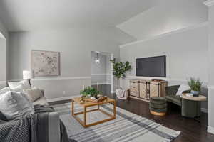 Living room featuring dark wood-type flooring and vaulted ceiling