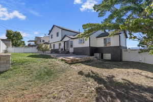 Rear view of property featuring a lawn and a patio