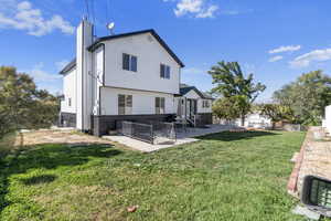 Back of house with a lawn and a patio area