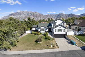 View of front of home featuring a garage, a mountain view, and a front lawn