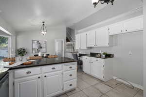 Kitchen featuring stainless steel dishwasher and white cabinetry