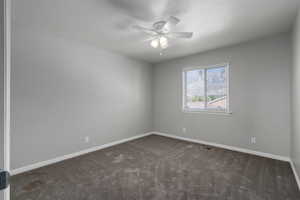 Carpeted empty room featuring ceiling fan