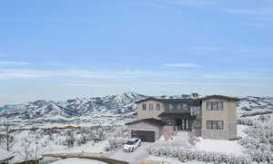 View of front of house with a mountain view and a garage