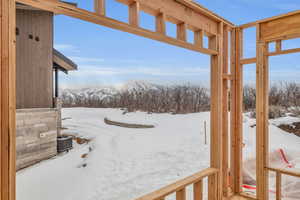 Yard layered in snow featuring a mountain view and central AC unit