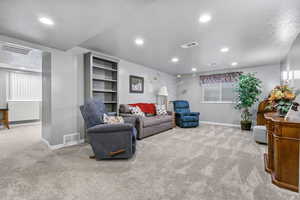 Living room with a textured ceiling and light colored carpet