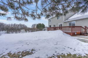 Yard layered in snow featuring a deck