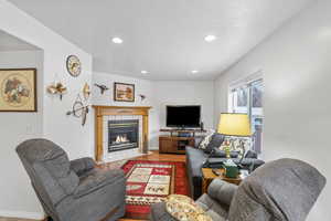 Living room with a tiled fireplace and hardwood / wood-style flooring